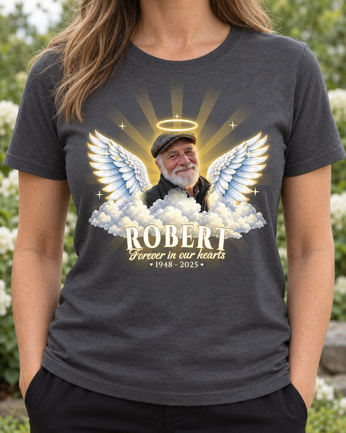 Woman wearing a charcoal in loving memory angel wings t-shirt with an older man's photo, a golden halo, wings and clouds, and the name Robert