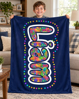 Boy holding up a navy blue custom name blanket reading Liam in bright doodle bubble letters