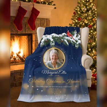 Personalized Christmas in Heaven memorial blanket with photo, name and years draped on an armchair by the fireplace