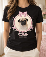 Black coquette dog shirt worn with cream trousers, showing a fawn pug in a cream lace cameo with pink satin bows, pearl strands and the script name Coco.