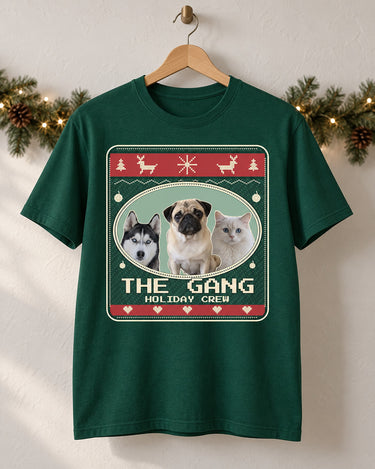 Forest green pet Christmas tee on a wooden hanger, showing three pets, The Gang lettering and red bands on an Evergreen sweater print