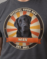 Close-up of the sunburst badge print on a charcoal t-shirt: a black Labrador, an orange ribbon with the name Max, Official Good Boy and Est. 2021 lettering