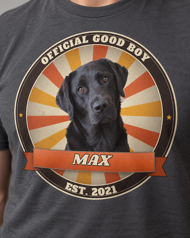 Close-up of the sunburst badge print on a charcoal t-shirt: a black Labrador, an orange ribbon with the name Max, Official Good Boy and Est. 2021 lettering