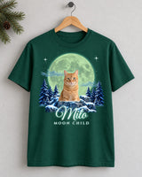 Forest green custom cat moon t-shirt on a wooden hanger with an orange tabby cat under an aurora-green moon and the name Milo