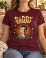 Woman wearing a maroon custom face bootleg rap tee with a man's portrait in a gold glow and the name Daddy