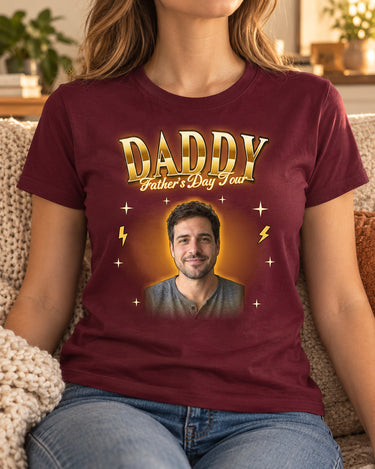Woman wearing a maroon custom face bootleg rap tee with a man's portrait in a gold glow and the name Daddy