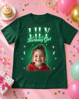 Forest green custom face bootleg rap tee laid flat on a pastel table with balloons, confetti, a cupcake with a candle and a gift, a girl's portrait and the name Lily