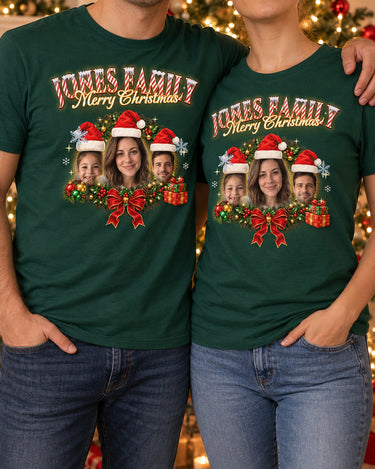 Couple standing in front of a Christmas tree in matching forest green face Christmas t-shirts with the family in Santa hats inside a holly wreath and the name Jones Family