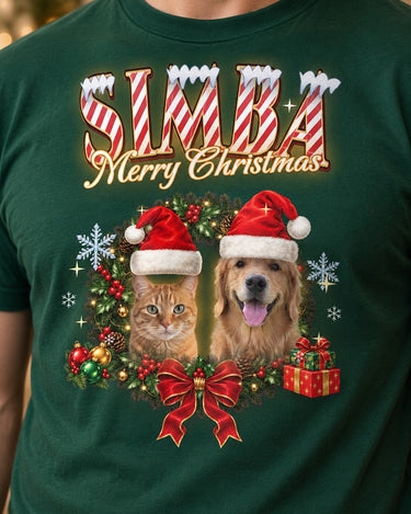 Close-up of the full-color print on a forest green pet Christmas t-shirt: Simba in candy-cane letters with a dog and a cat in Santa hats in a holly wreath