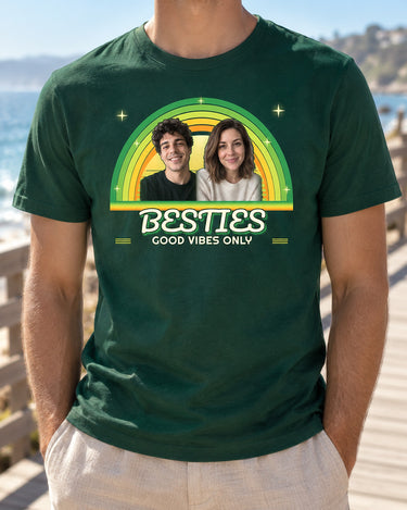Forest green retro photo shirt worn on a sunny boardwalk, showing two portraits, green and yellow sunset arcs and BESTIES with Good Vibes Only underneath.
