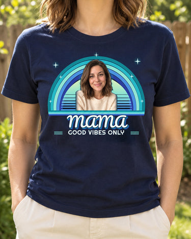 Navy 70s rainbow photo tee worn in a backyard, with one portrait, turquoise and blue sunset arcs and MAMA in layered groovy lettering.