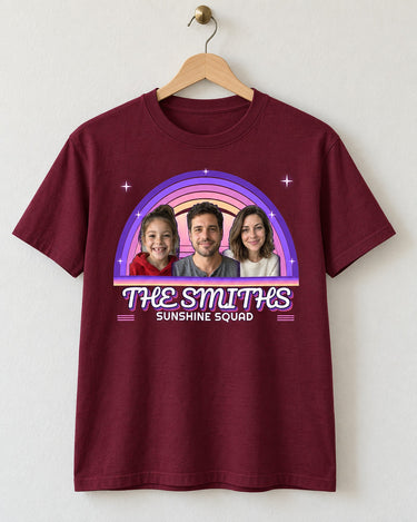 Maroon vintage sunset photo tee on a wooden hanger, showing three portraits inside purple and pink rainbow arcs with THE SMITHS and Sunshine Squad.