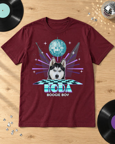 Maroon disco pet tee laid on pale oak with vinyl records, sequins and a small disco ball, featuring a husky and cyan Koda lettering.