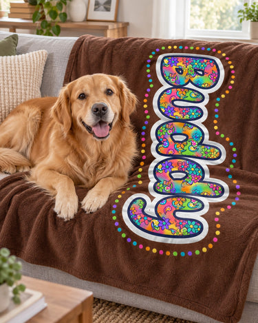Golden retriever lying on a coffee brown personalized name blanket reading Buddy on a sofa