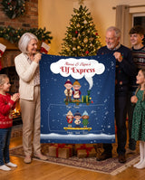 Personalized family Elf Express blanket with names, grandma and grandpa holding a navy Christmas blanket with little elves riding a toy train, grandkids around the tree
