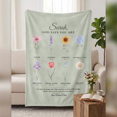 Personalized Christian blanket God Says You Are with name, watercolor flowers and Bible verse on a sage throw over the sofa