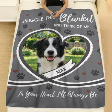 Grey heart pet photo blanket with paw prints laid across a made bed