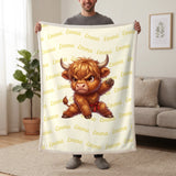 Personalized Highland cow karate blanket in lemon cream held up in a living room, with the name Emma repeated in soft waves
