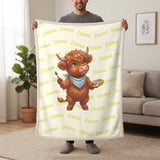 Personalized Highland cow painter blanket in lemon cream held up in a living room, with the name Emma repeated in soft waves