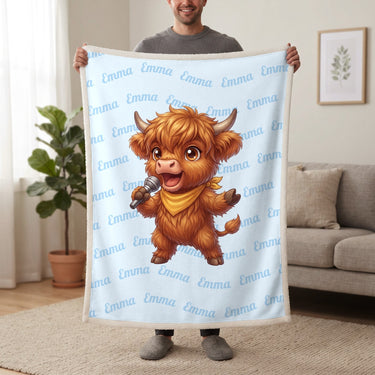 Personalized Highland cow singer blanket in baby blue held up in a living room, with the name Emma repeated in soft waves