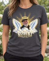 Woman wearing a charcoal in loving memory angel wings t-shirt with an older man's photo, a golden halo, wings and clouds, and the name Robert