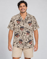 Island Tiki Vibes Hawaiian shirt with printed faces, worn by a man
