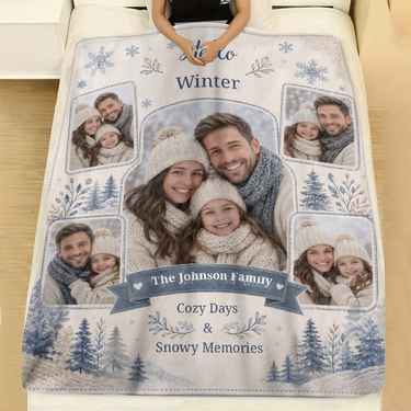 Personalized Hello Winter family blanket with watercolour snowflakes, blue pine trees and a navy name ribbon spread across a made bed with white linen