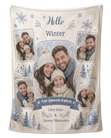 Personalized Hello Winter photo blanket in cream and dusty blue, printed with five family photos in soft white frames, watercolour snowflakes and pines, and the family name on a navy ribbon, shown flat on a pure white background