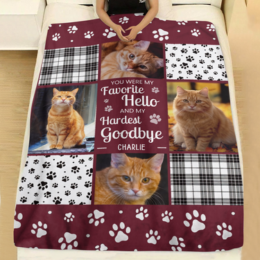 Custom pet loss keepsake blanket with four photos of a beloved cat, paw print borders and plaid squares spread across a made bed with white linen