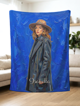 Hand held personalized oil painting blanket showing a painted woman in a wide-brim hat on cobalt blue brushstrokes with the name Isabella