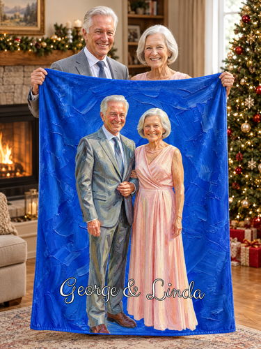 A senior couple holding up their anniversary oil painting blanket by the fireplace at Christmas, printed with their portrait on cobalt blue brushstrokes and the names George & Linda