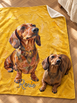 Custom dachshund portrait blanket laid on a herringbone wood floor, oil painted on sunflower yellow brushstrokes with the name Rosie, with the real dachshund lying on the corner