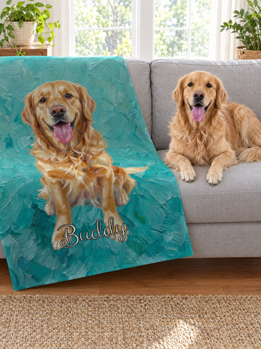 Personalised golden retriever oil painting blanket thrown diagonally over a grey sofa, the painted dog and the name Buddy following the drape from the back cushion across the seat, turquoise brushstrokes, with the real golden retriever resting beside it
