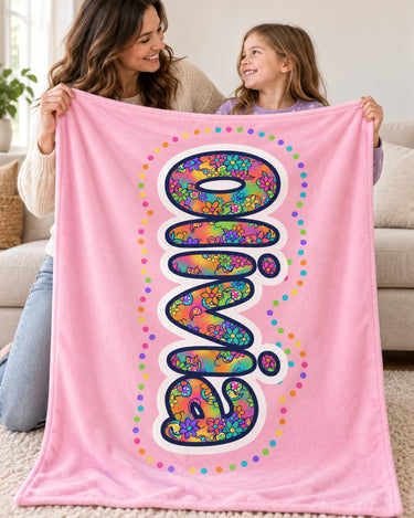 Mother and daughter holding a light pink personalized name blanket reading Olivia together