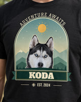 Close-up of the black mountain pet tee with Koda the husky, cream slab-serif lettering, green mountain layers, golden sun and a bordered arch.