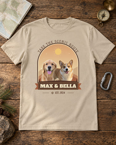 Sand pet mountain shirt with Max and Bella in warm rust scenery, laid on a cabin table beside a folded map, brass compass and metal carabiner.