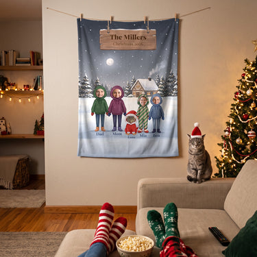 Family Christmas blanket with teen kids and a cat in a Santa hood hung above the sofa