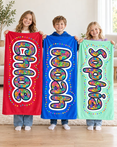 Three siblings holding custom name blankets in red, blue and mint reading Chloe, Noah and Sophia in paisley-filled bubble letters