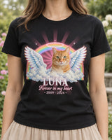 Woman wearing a black pet memorial t-shirt with a tabby cat with angel wings and a halo over a rainbow, the name Luna in white letters with a rose pink light