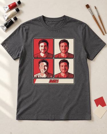 Charcoal pop art portrait shirt laid on an ivory studio table beside paint tubes, brushes and color swatches, showing the red and cream print.