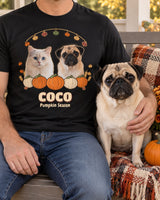 Adult wearer cropped below the chin beside a fawn pug on a porch bench, wearing a black custom fall pet photo shirt with pumpkins and maple leaves.