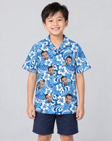 Royal Blue Tropics Hawaiian shirt with printed faces, worn by a child