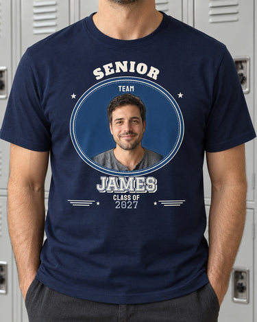 Navy JAMES senior photo shirt against a grey locker wall, with a single portrait, navy and silver varsity outlines and the class year 2027.