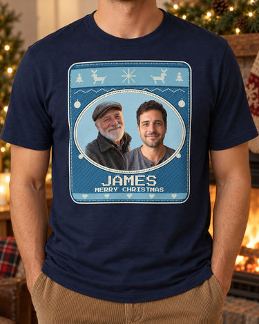 Navy Christmas portrait tee beside a fireplace, with two portraits, the name James and cream pixel lettering on an Icy Blue sweater print