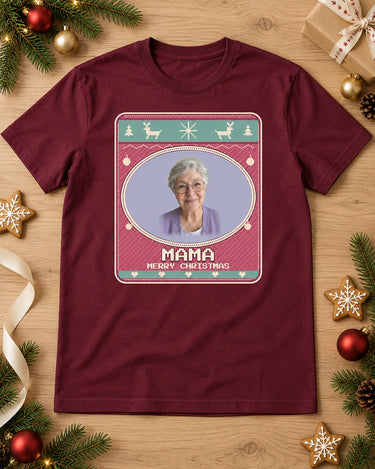Maroon face photo Christmas tee laid on oak with pine branches, ornaments and cookies, showing Mama in a Candy Pink sweater print