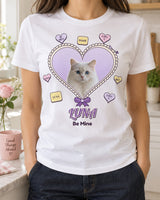 White pet Valentine shirt with Luna the cat inside a lavender heart, cream scalloped edging, conversation candies and Be Mine lettering in a bright kitchen.
