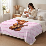 Mother holding a newborn on a bed covered with a pink Highland cow name blanket
