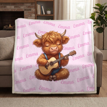 Pink Highland cow name blanket draped over a sofa by the fireplace