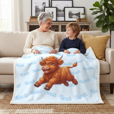 Grandmother and grandson under a baby blue running Highland cow blanket with the name Noah