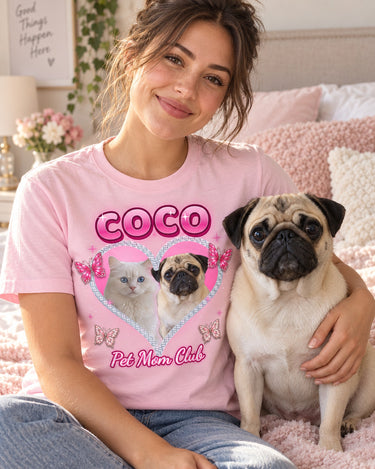 Smiling woman with her pug on a bed with pastel pillows, wearing a light pink Y2K pet t-shirt that shows the same pug in a sparkling heart